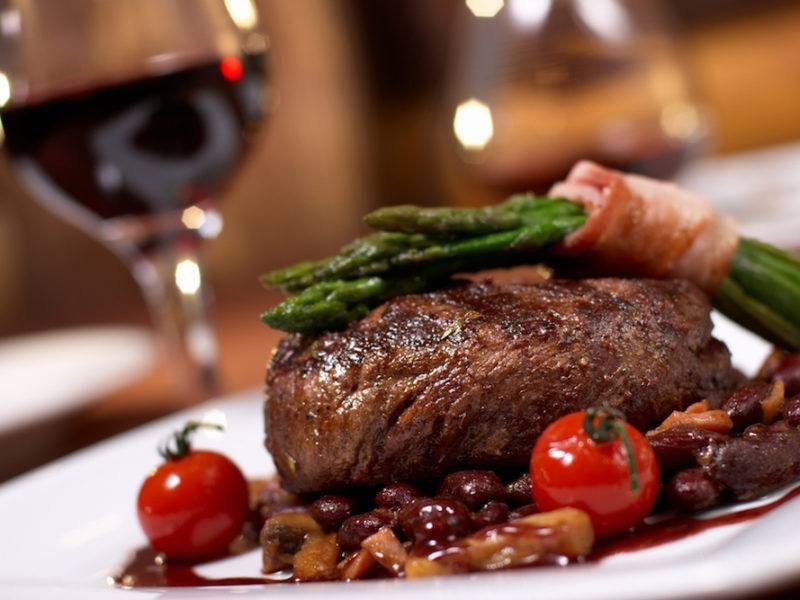 A gourmet steak dinner with wine.