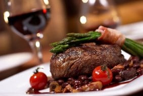 A gourmet steak dinner with wine.