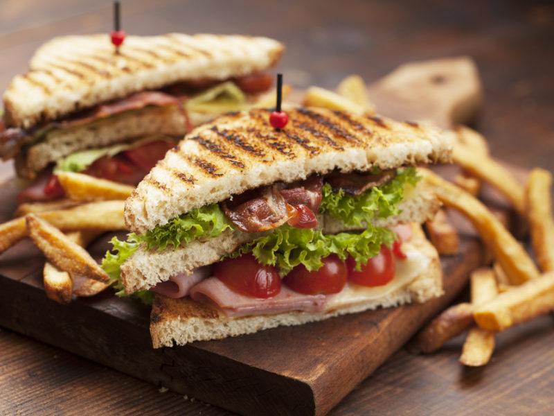 Tasty club sandwiches and french fries.