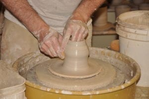person making pottery on a pottery wheel